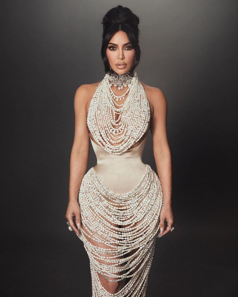 Kim Kardashian de frente sobre un fondo oscuro luce su vestidod e perlas y corset para su Instagram